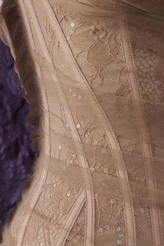 Close-up of a wooden chair leg and patterned fabric with 'Alexander McQueen' branding.
