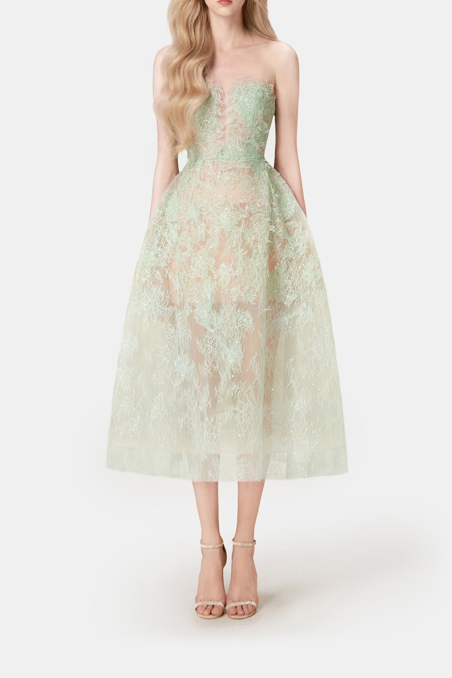 A model wearing an elegant mint beaded lace midi dress with a fitted bodice and flowing skirt, paired with heels.