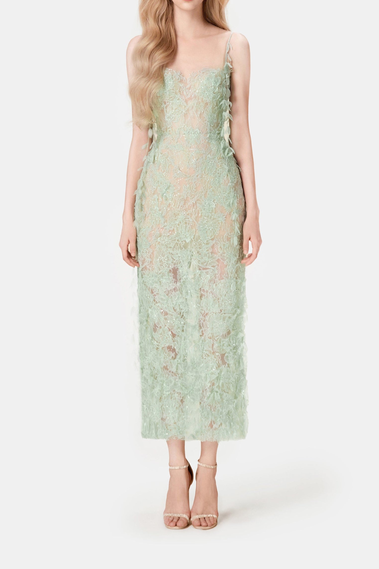 Woman wearing a light green lace dress on a white background