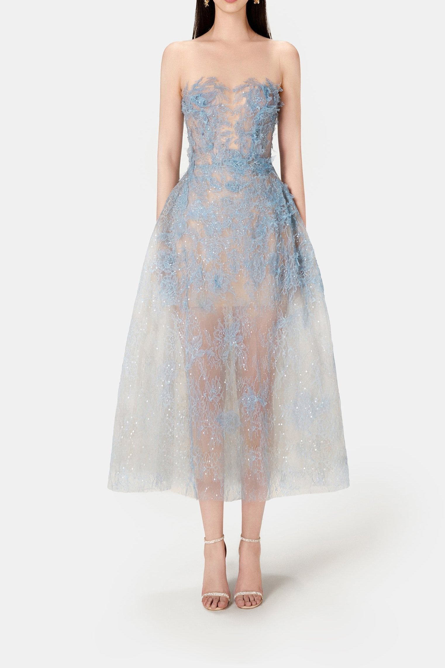 A model wearing a blue beaded lace mini dress with a fitted bodice and flowing skirt, standing against a white background.